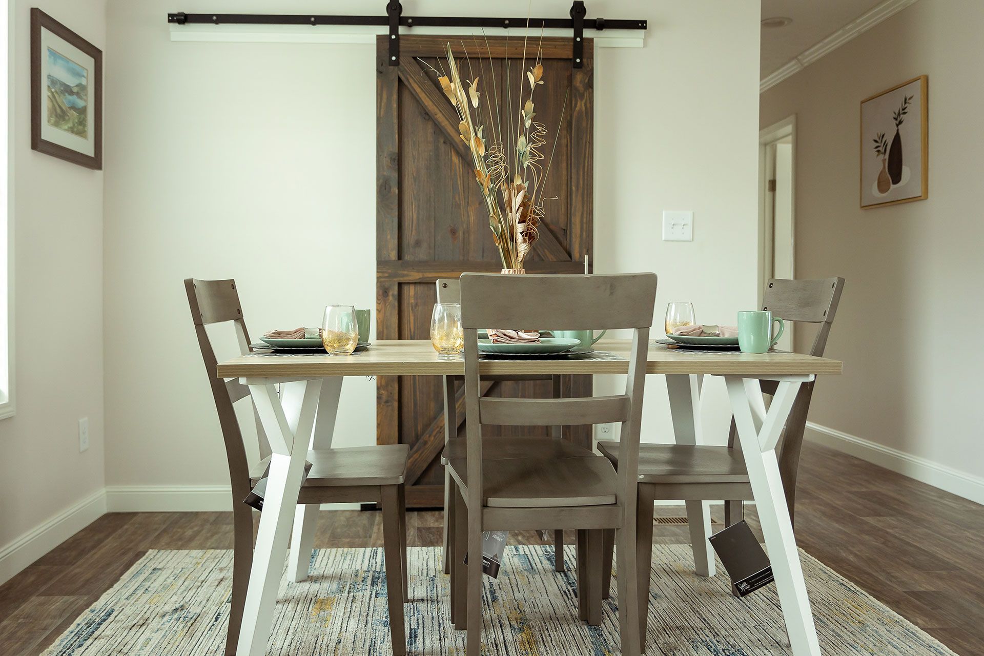 A dining room with a table and chairs and a sliding barn door