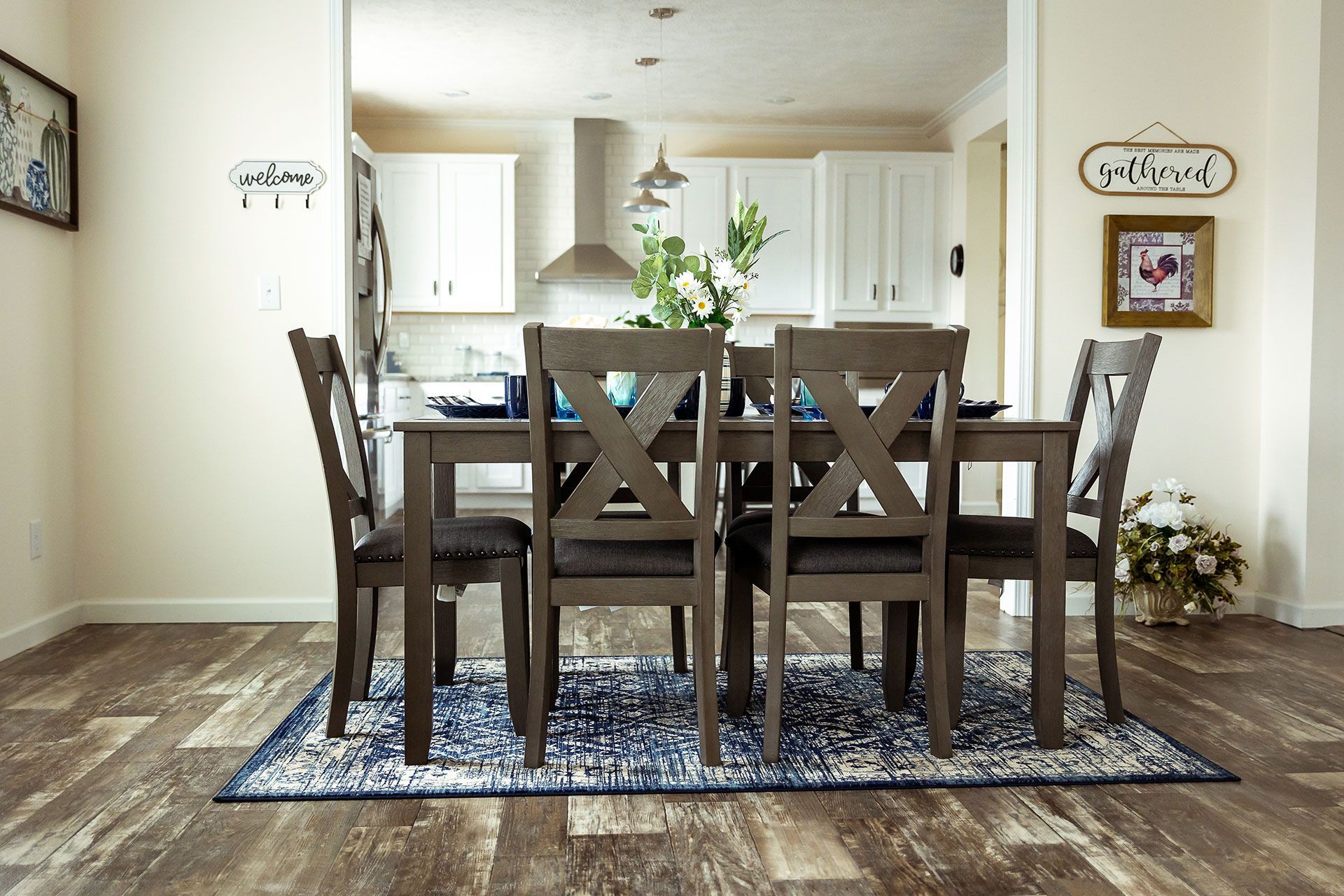 A dining room with a table and chairs and a rug on the floor