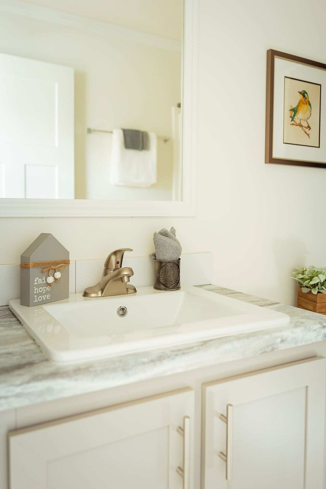 A bathroom with a sink, mirror, and cabinets