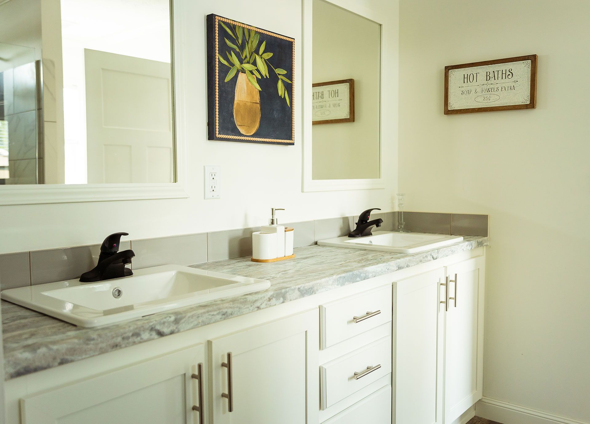 A bathroom with two sinks and two mirrors