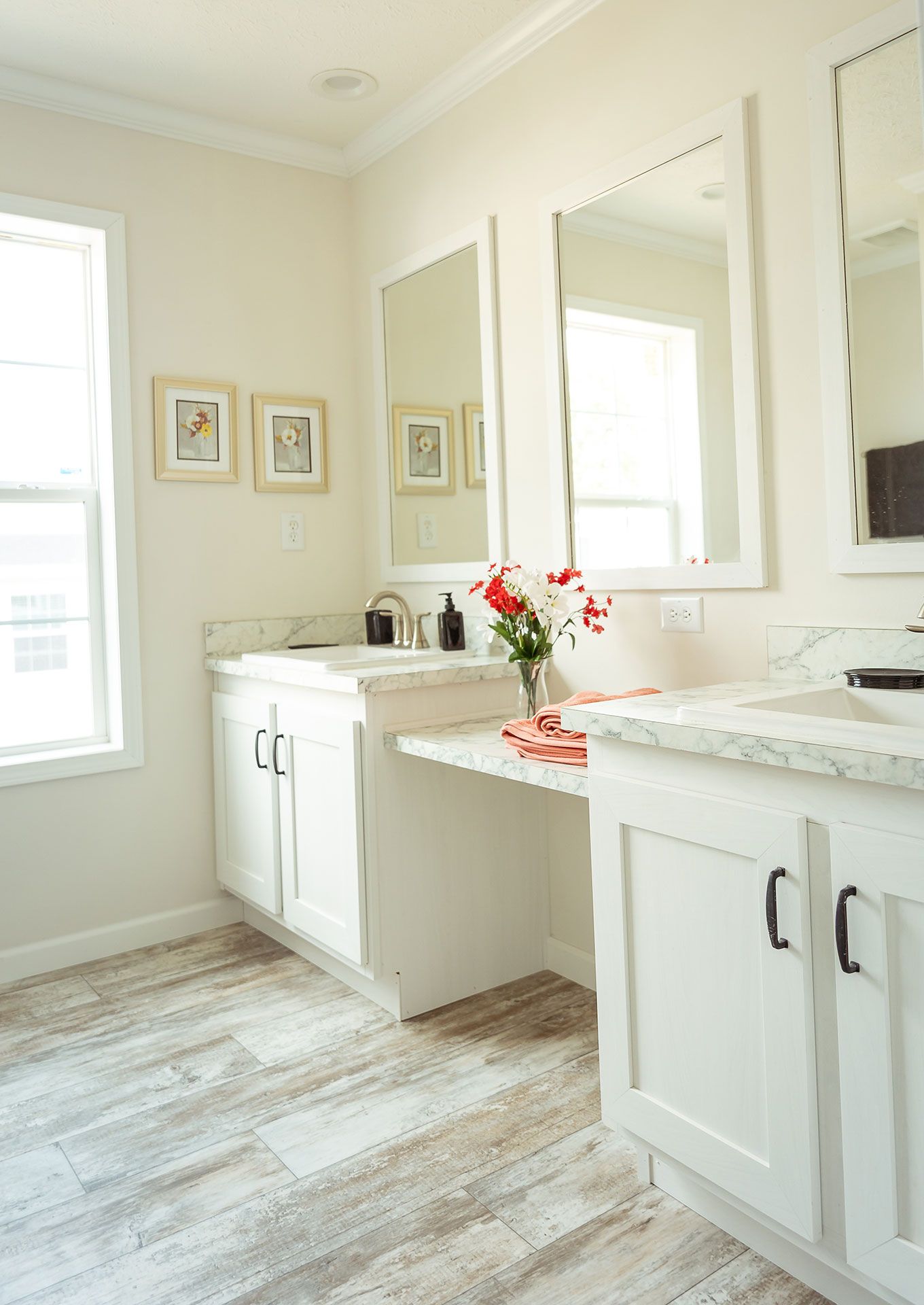 A bathroom with two sinks, a mirror, and a window