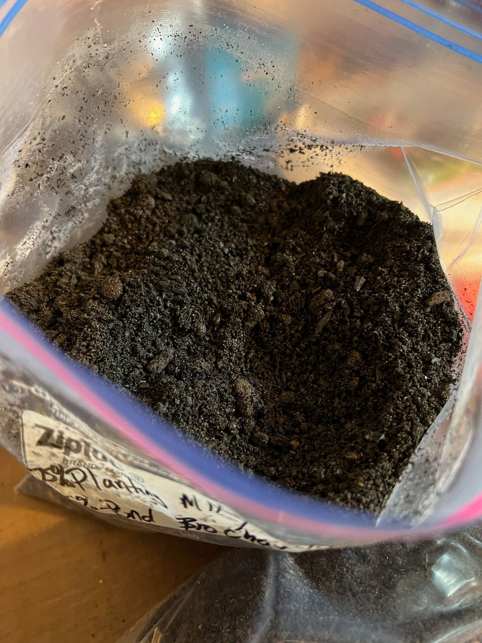 Black, grainy substance in a clear Ziploc bag, labeled with writing.