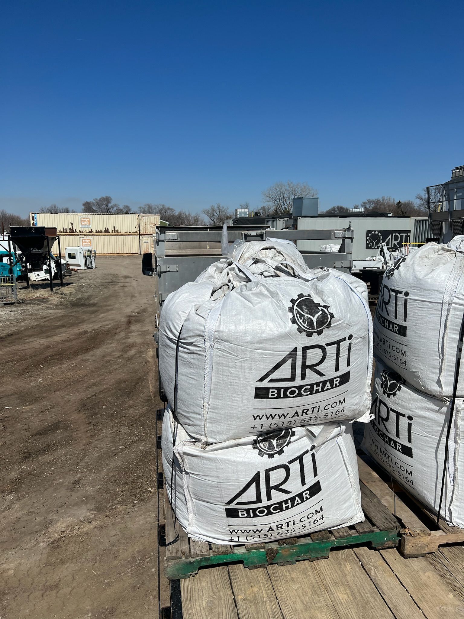 Two large white bags stacked on a wooden pallet; 