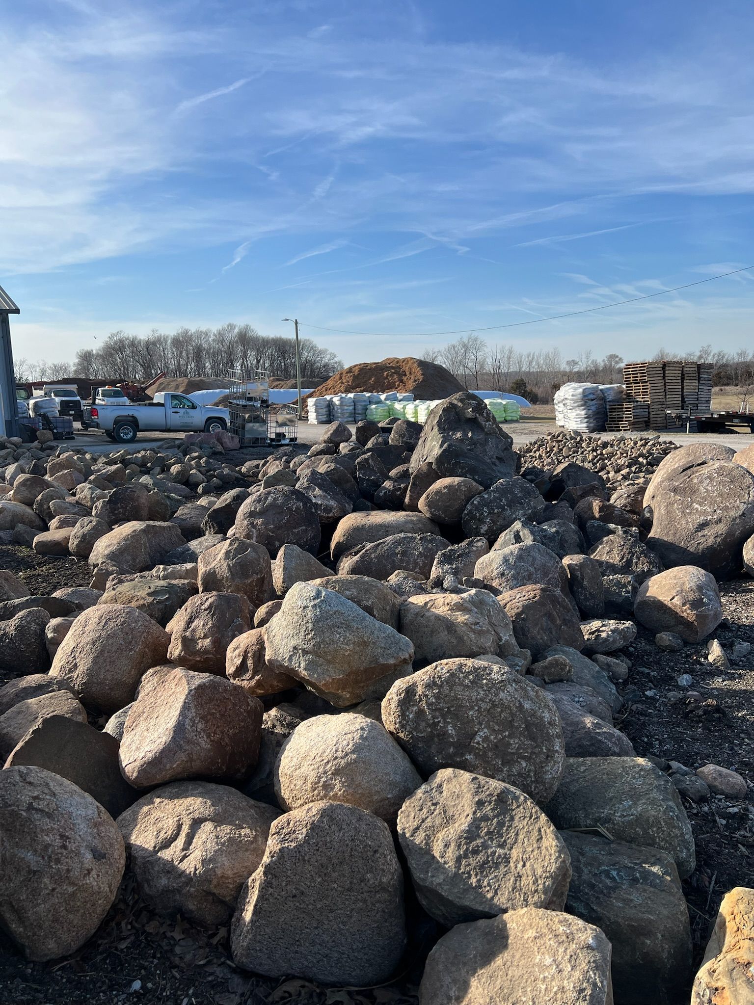Pile of various sized rocks, with shades of brown, gray, and green.