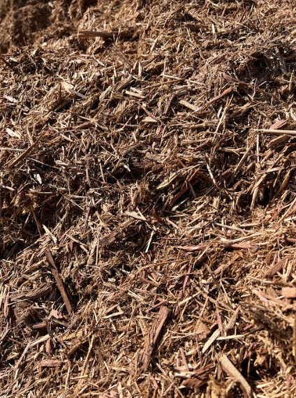 Pile of brown wood mulch, consisting of shredded wood pieces.