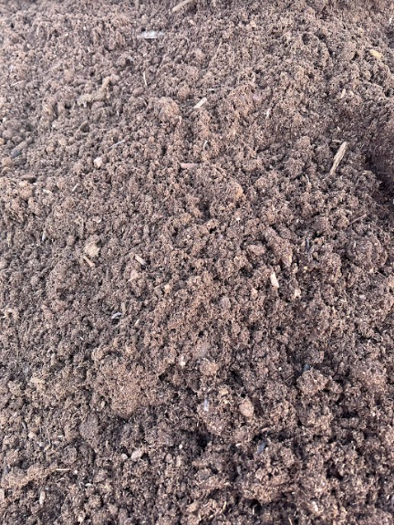 Close-up of dark brown, textured soil; looks moist and rich.