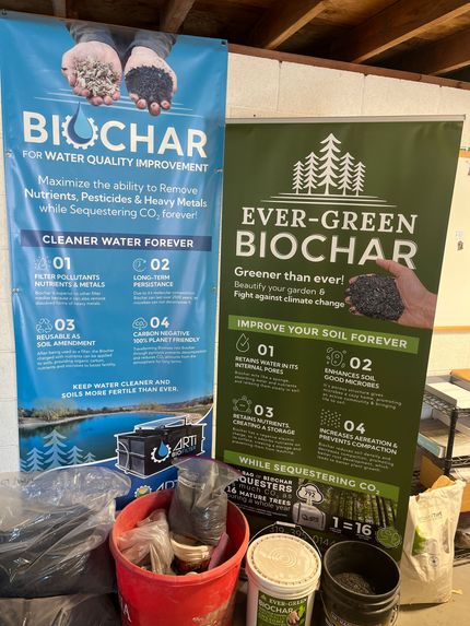 Two banners promoting biochar. One is blue, for water improvement, the other green, for soil improvement. 