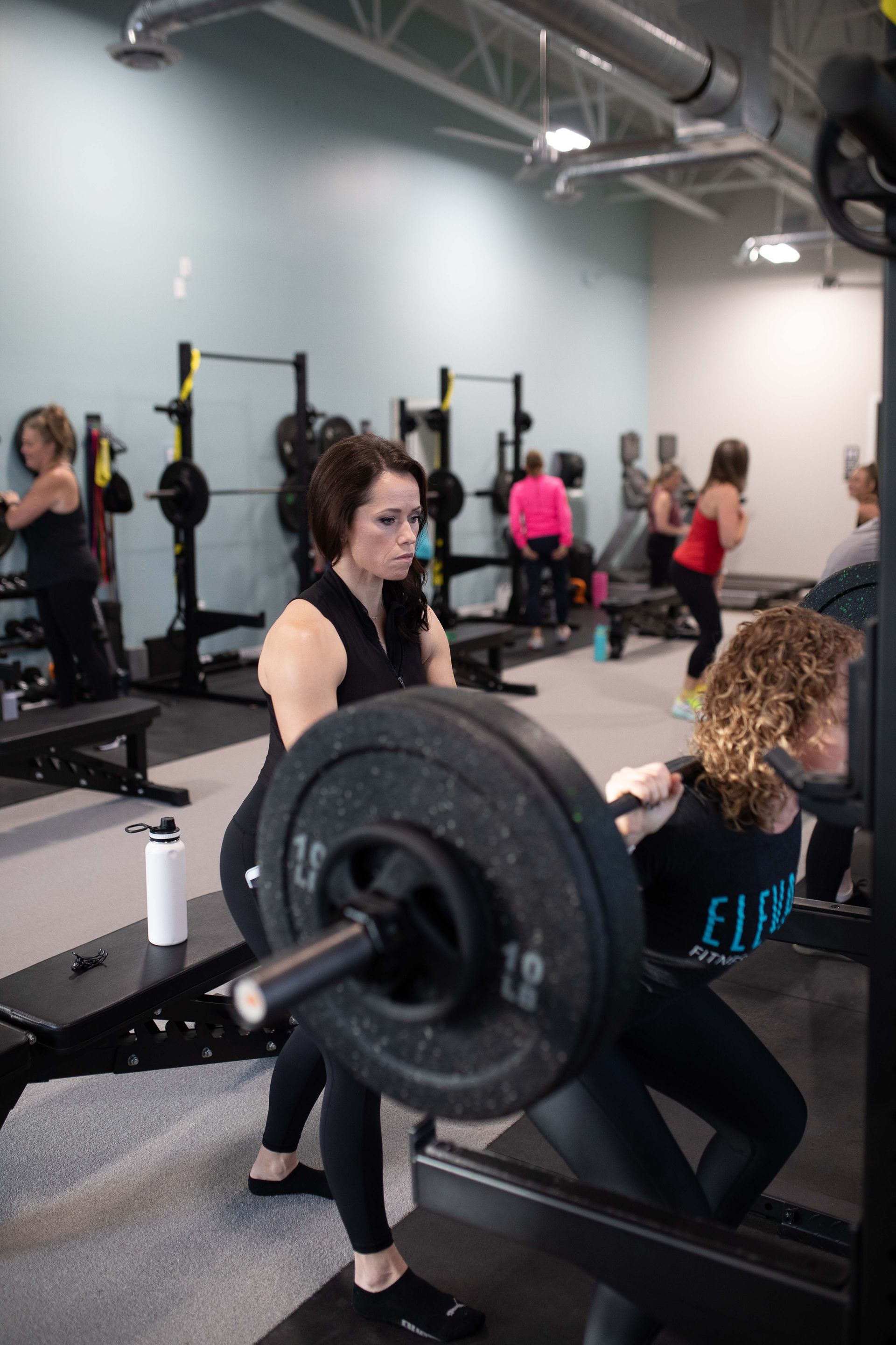 Woman doing squats with a personal trainer