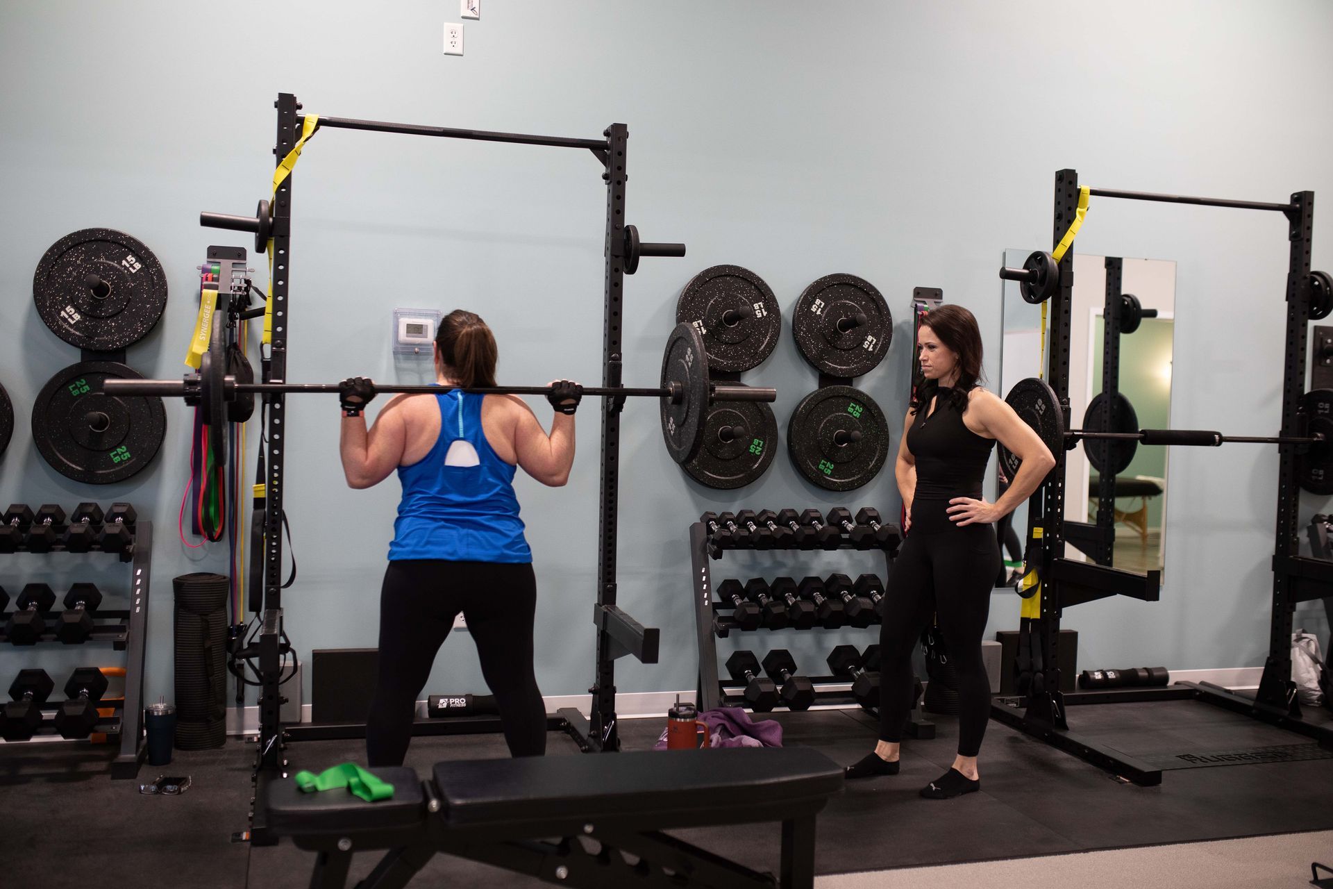 Woman doing squats with a personal coach