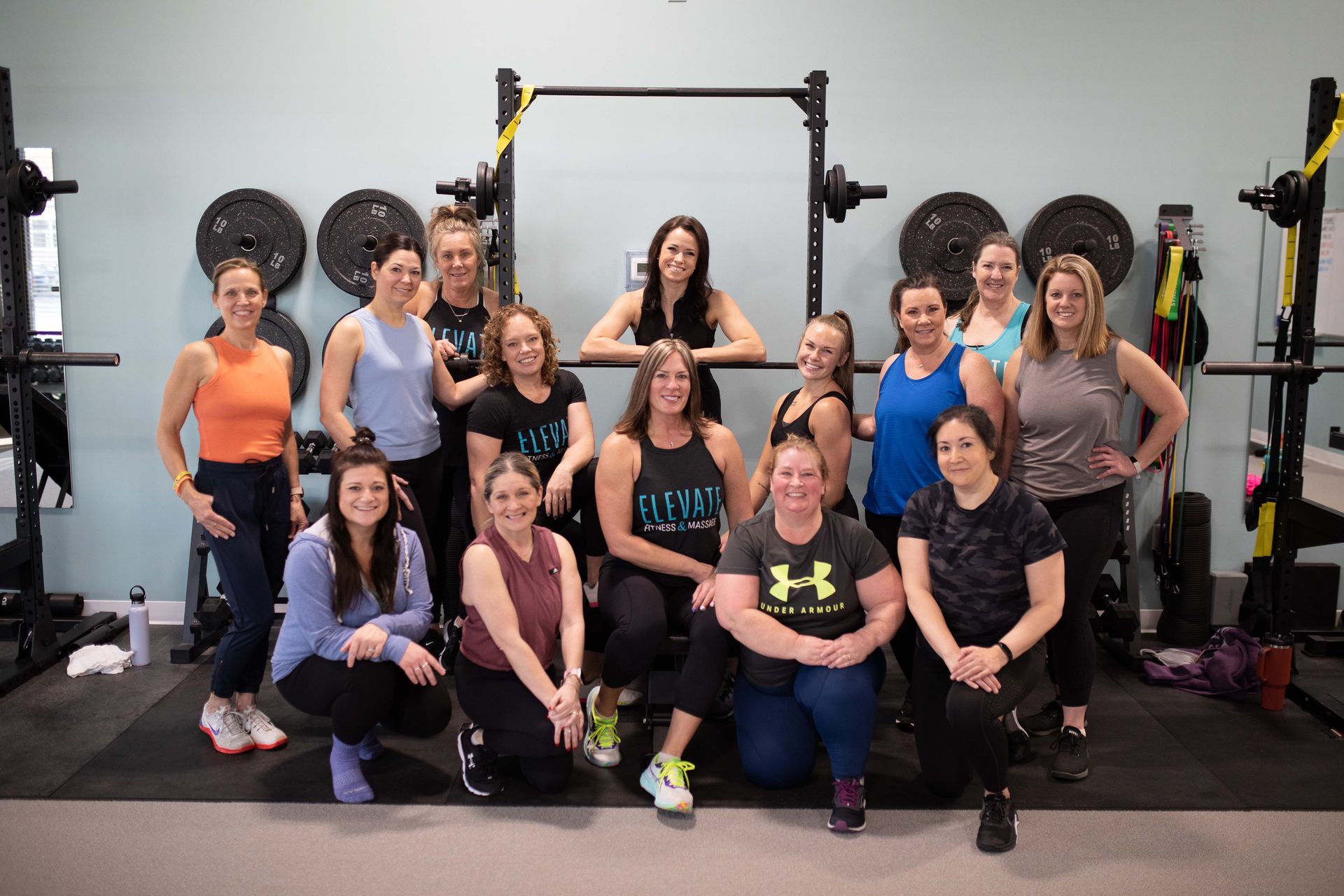A group of women are posing for a picture in a gym.