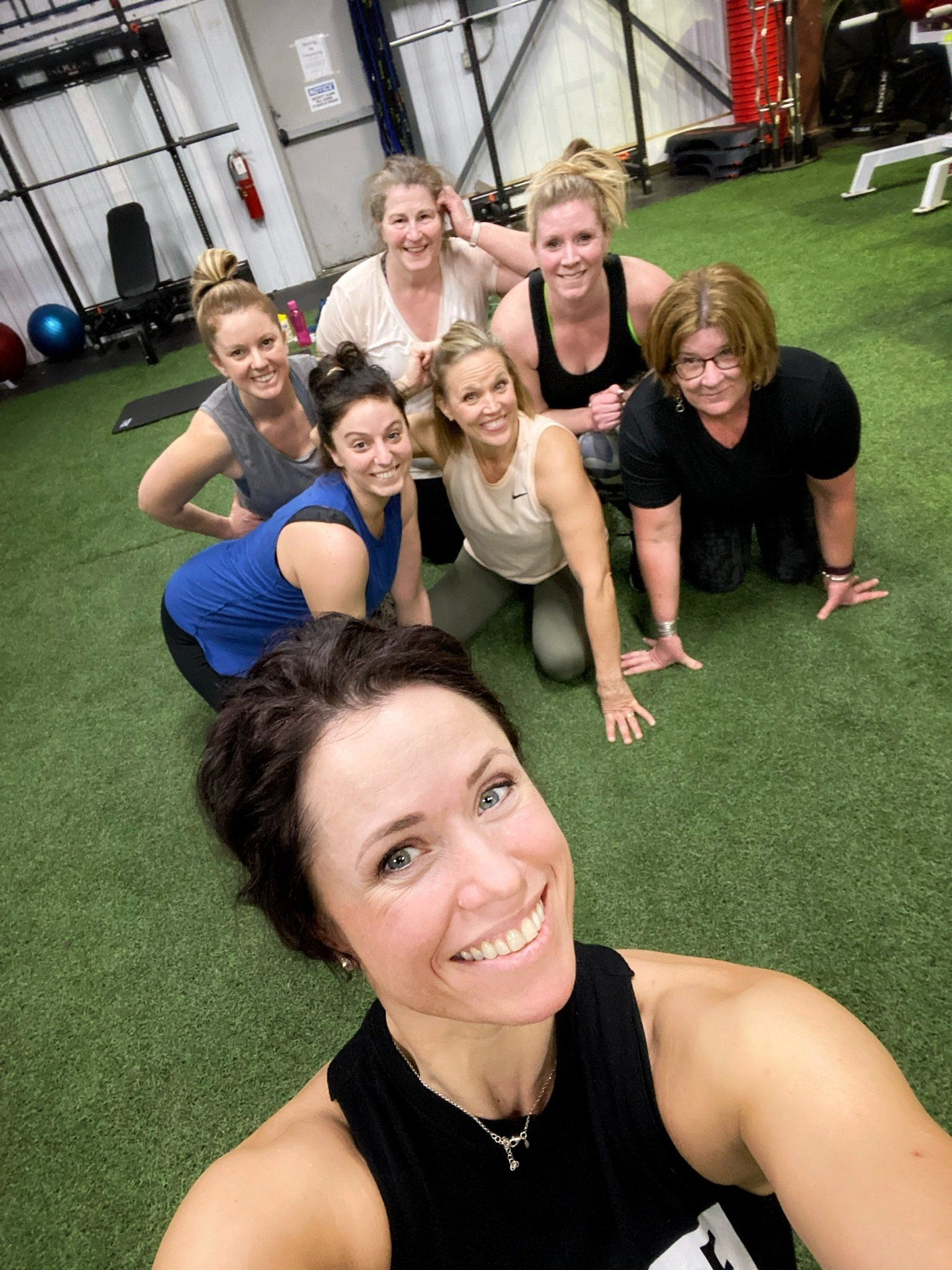 A group of women are posing for a selfie in a gym