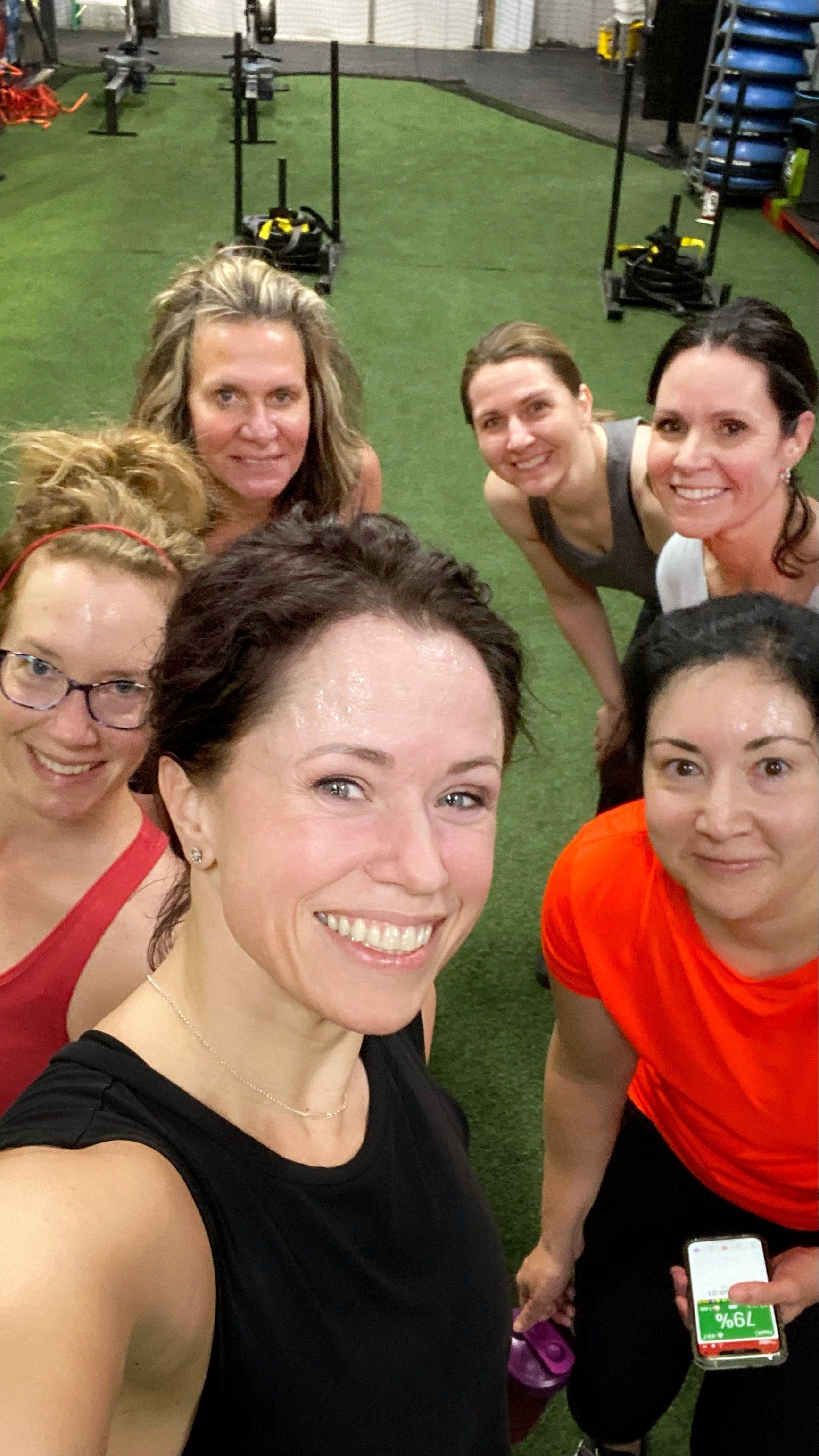 A group of women are posing for a picture in a gym
