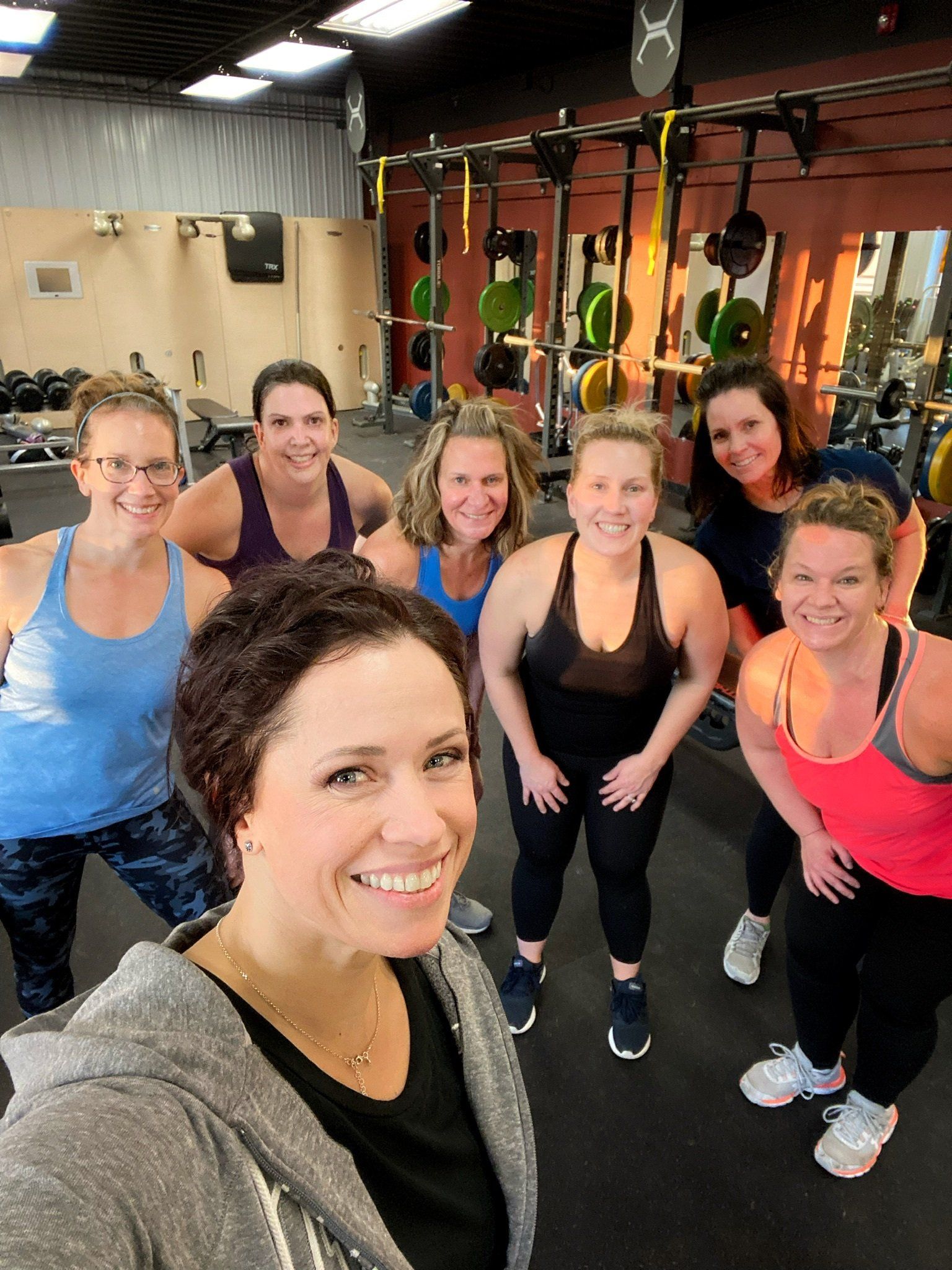A group of women are posing for a picture in a gym