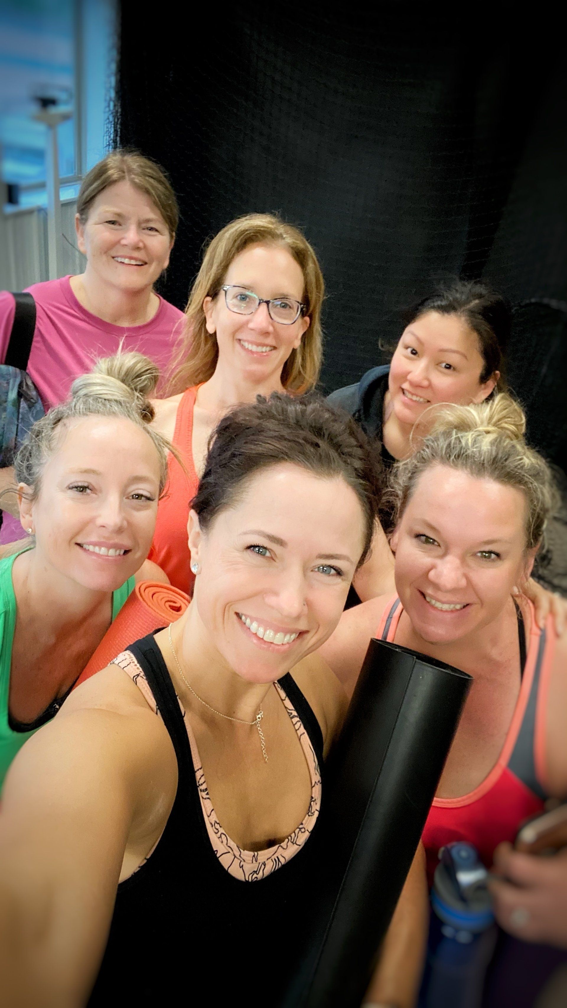 A group of women are posing for a selfie in a gym