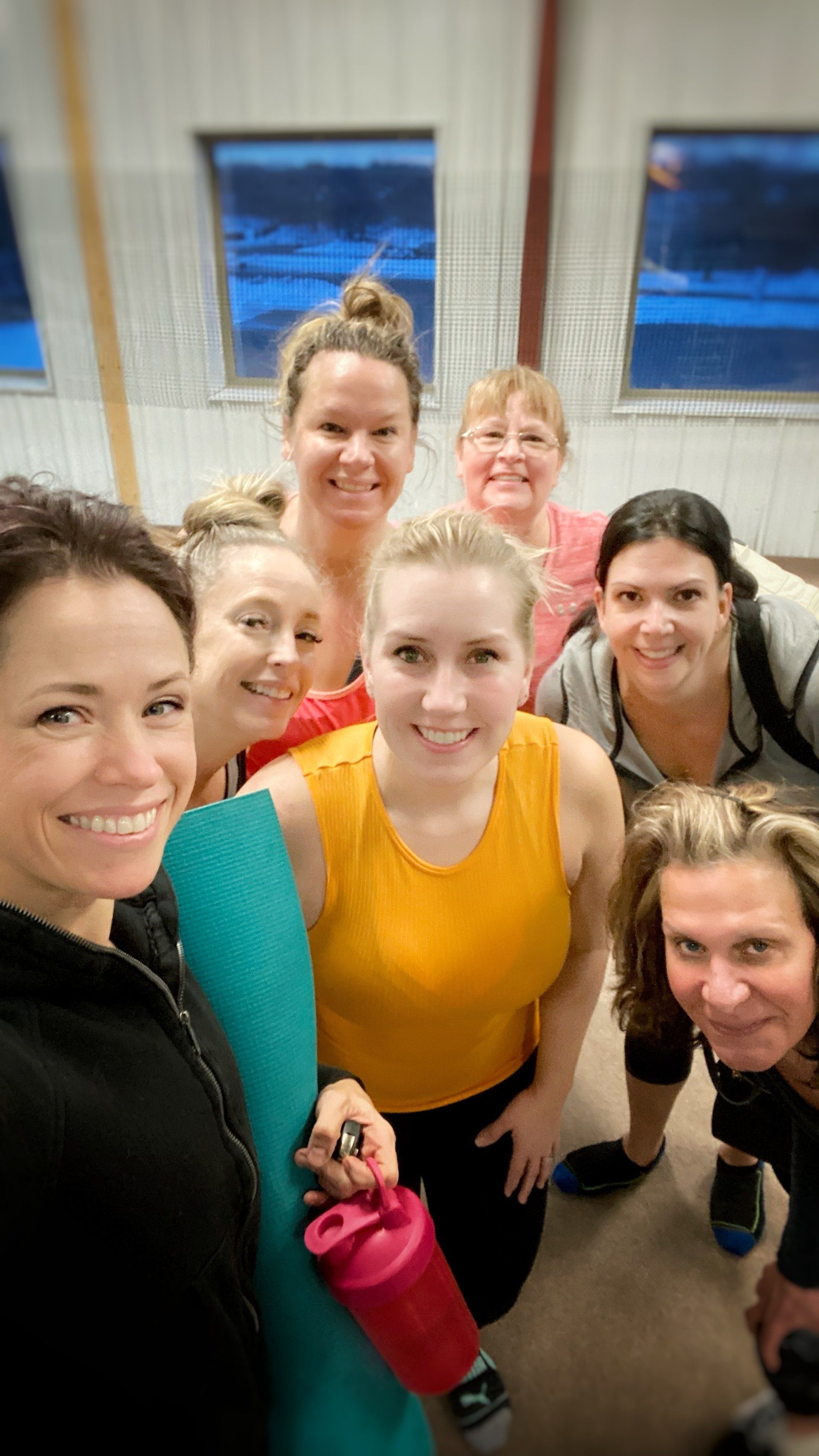 A group of women are posing for a picture in a gym