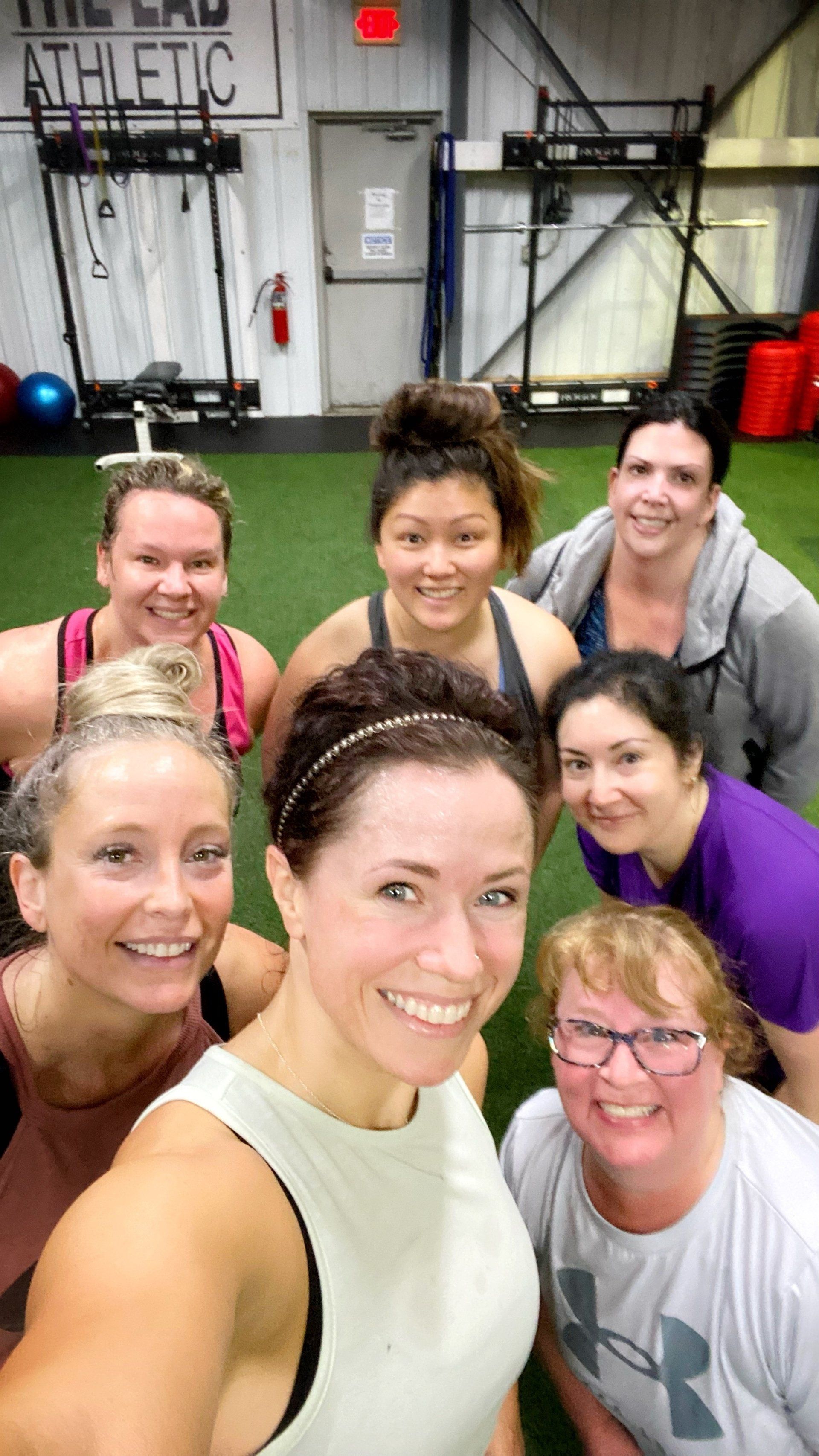 A group of women are posing for a selfie in a gym
