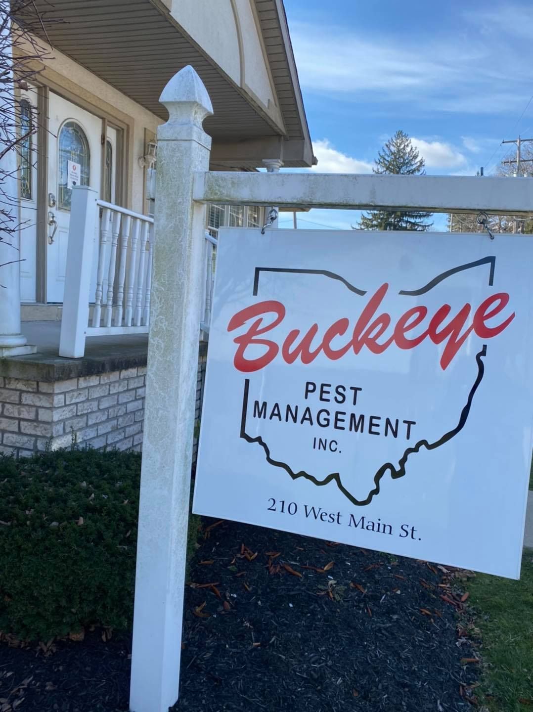 Buckeye Pest Management sign beside a house, with Ohio outline and red script logo.