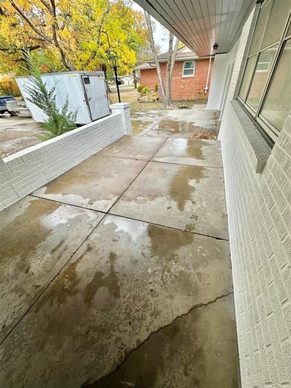 A brick building with a concrete walkway leading to it.