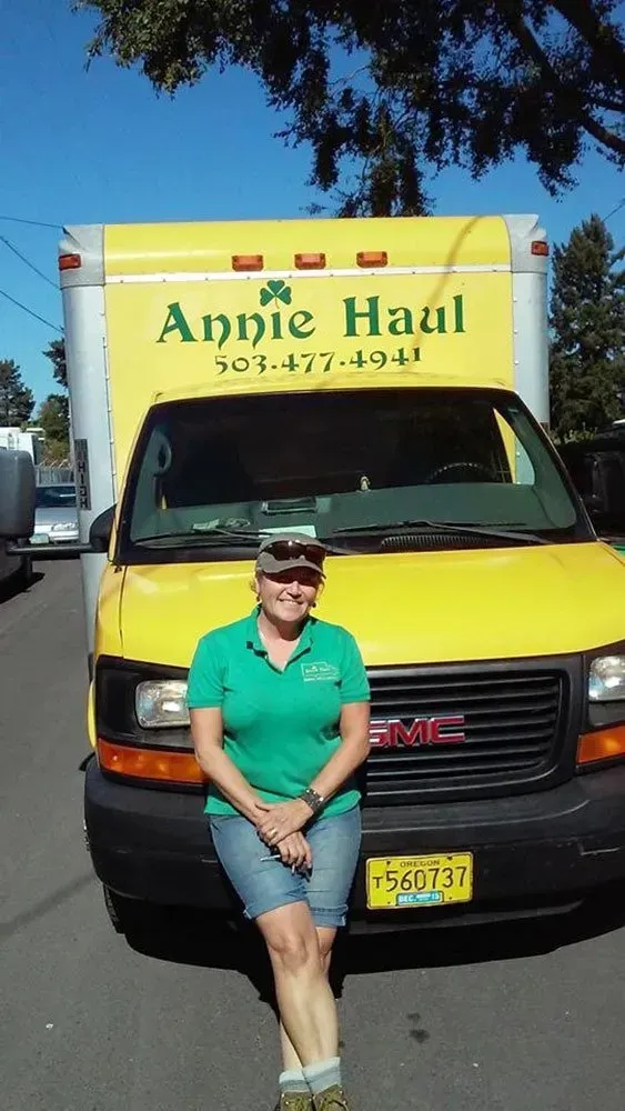 Woman in green shirt stands in front of a yellow 