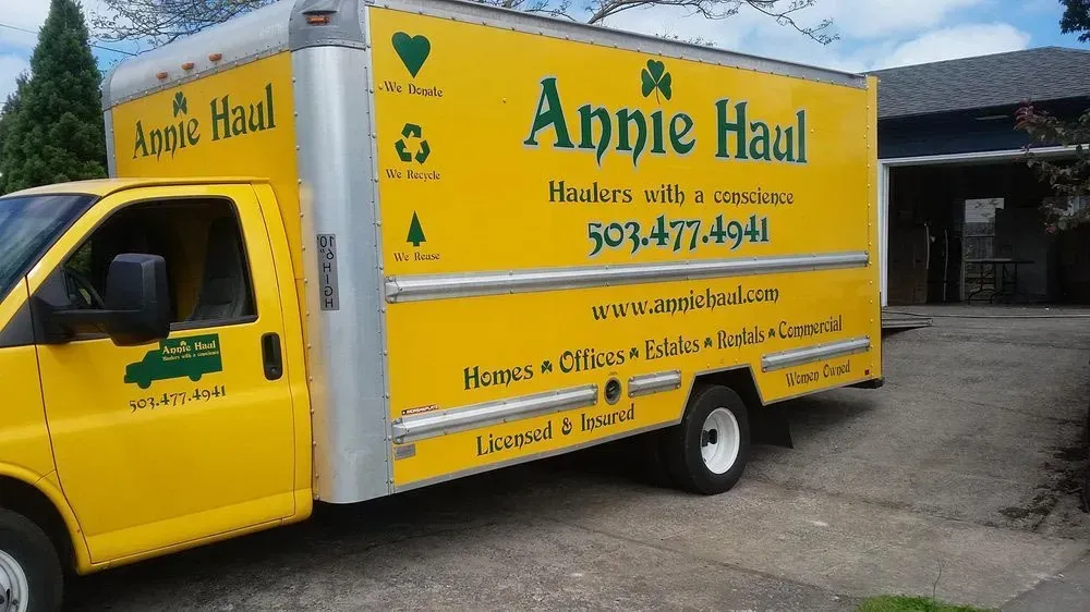Yellow Annie Haul moving truck parked in a driveway; contact info and services listed.