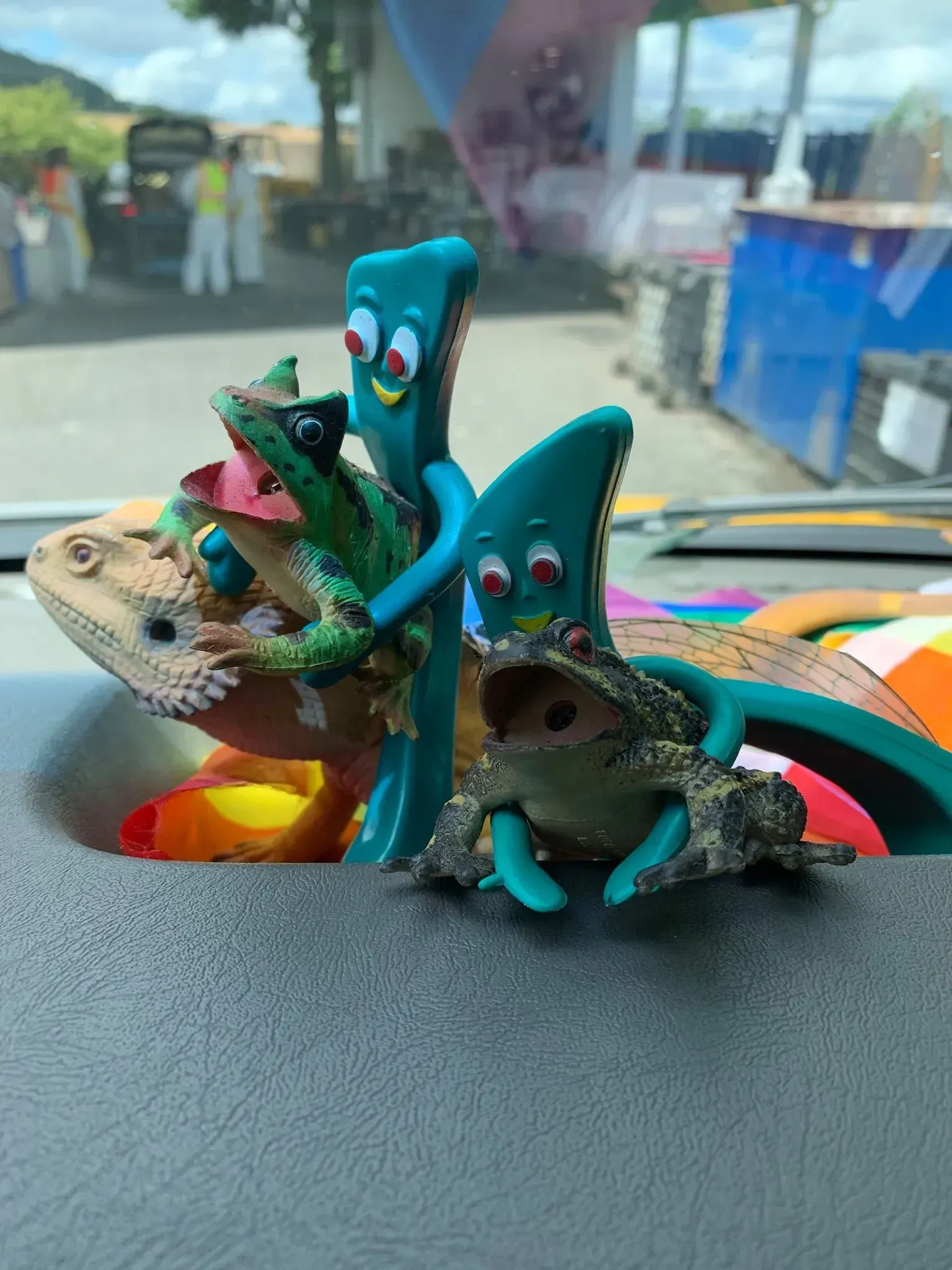Dashboard with a bearded dragon, frog, and two Gumby figures.