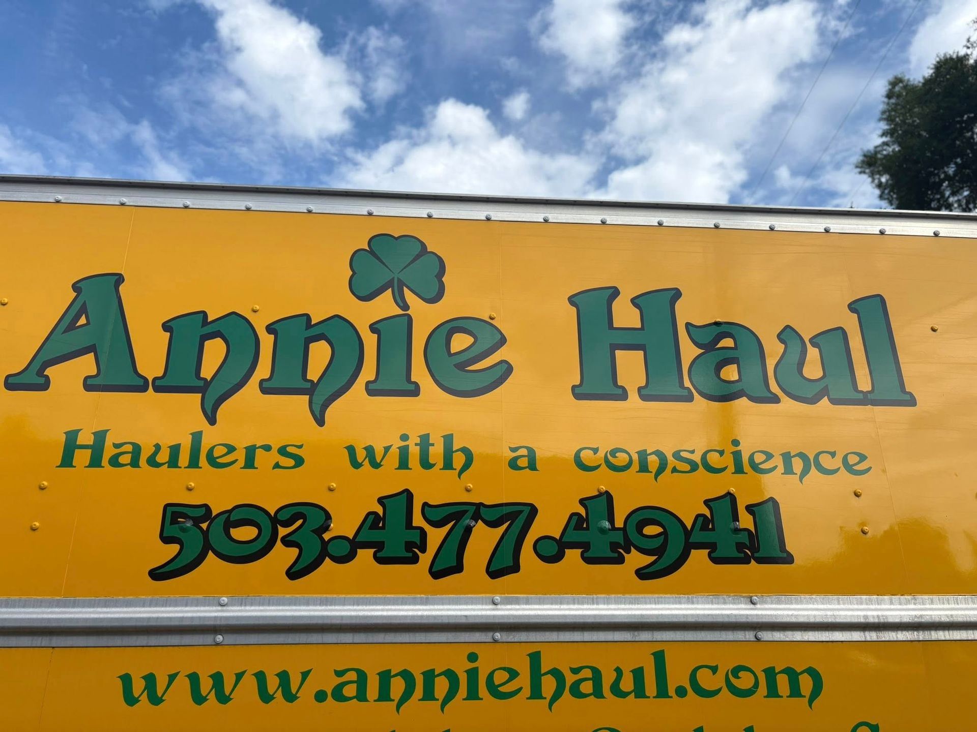 Yellow truck with green lettering reads 