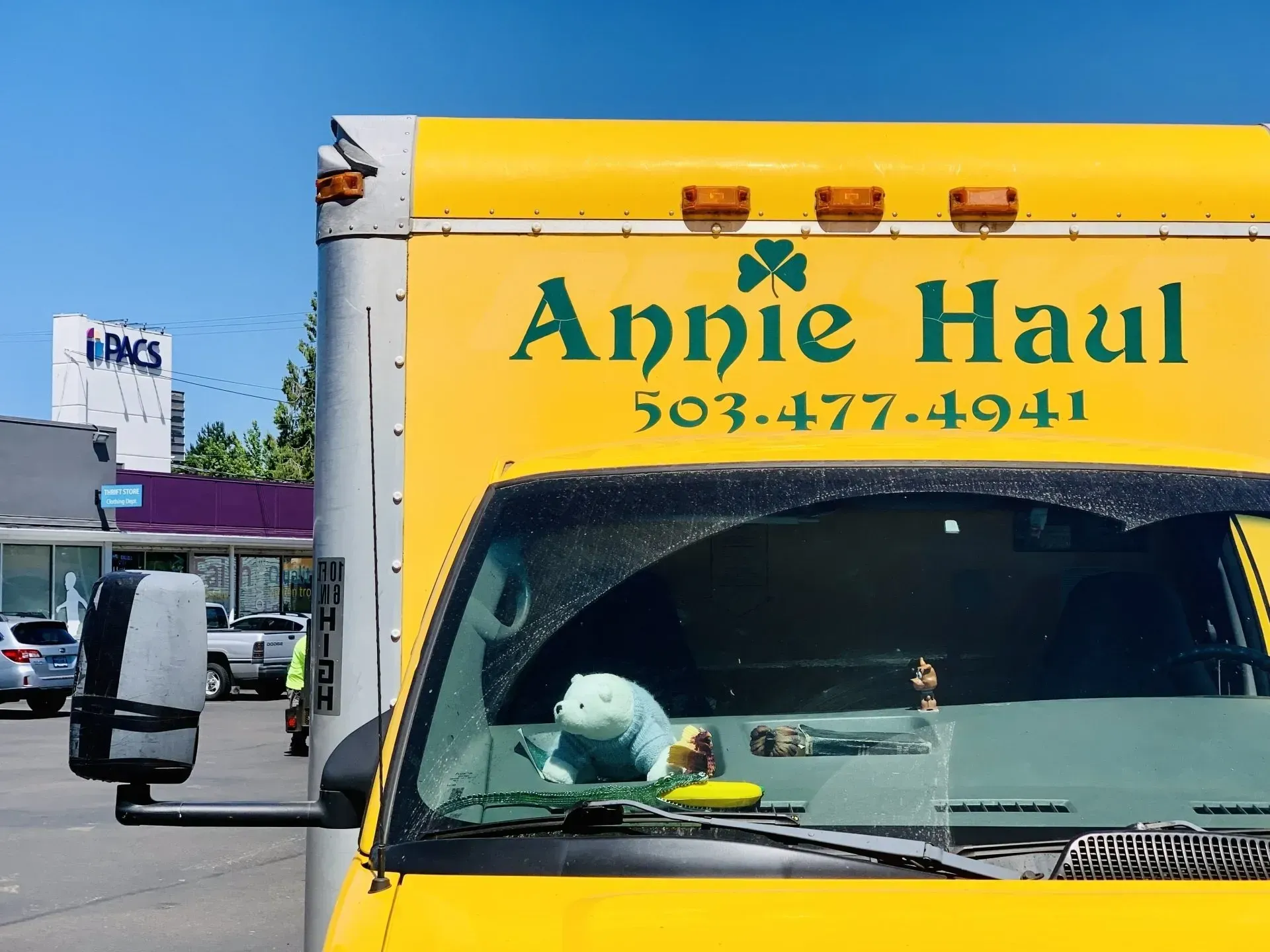 Yellow Annie Haul moving truck, phone number 503-477-4941, parked outside with businesses in background.