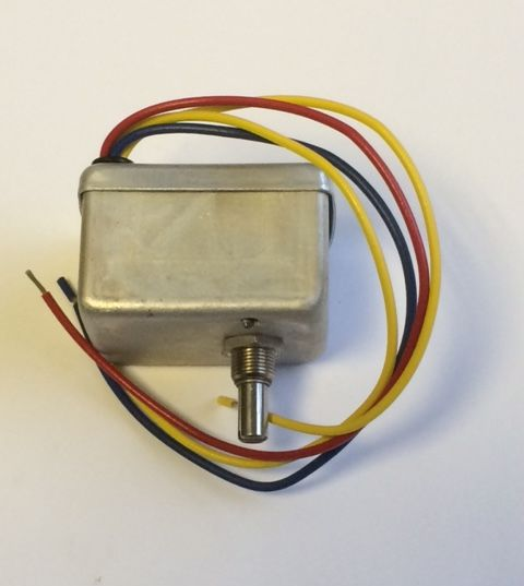 Small metal electric motor with red, yellow, and black wires on a white background