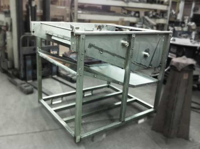 Grey fabrication machine in a factory.