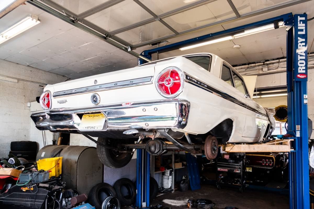 White vintage car on a lift in a garage, rear view.