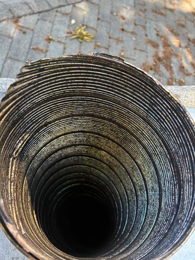 Top view of a deep cylindrical pipe or shaft with dark interior and concentric ridges