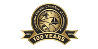 Charlotte County Chamber of Commerce logo celebrating 100 years. Gold emblem with a boat, palm tree, and the years 1925-2025.