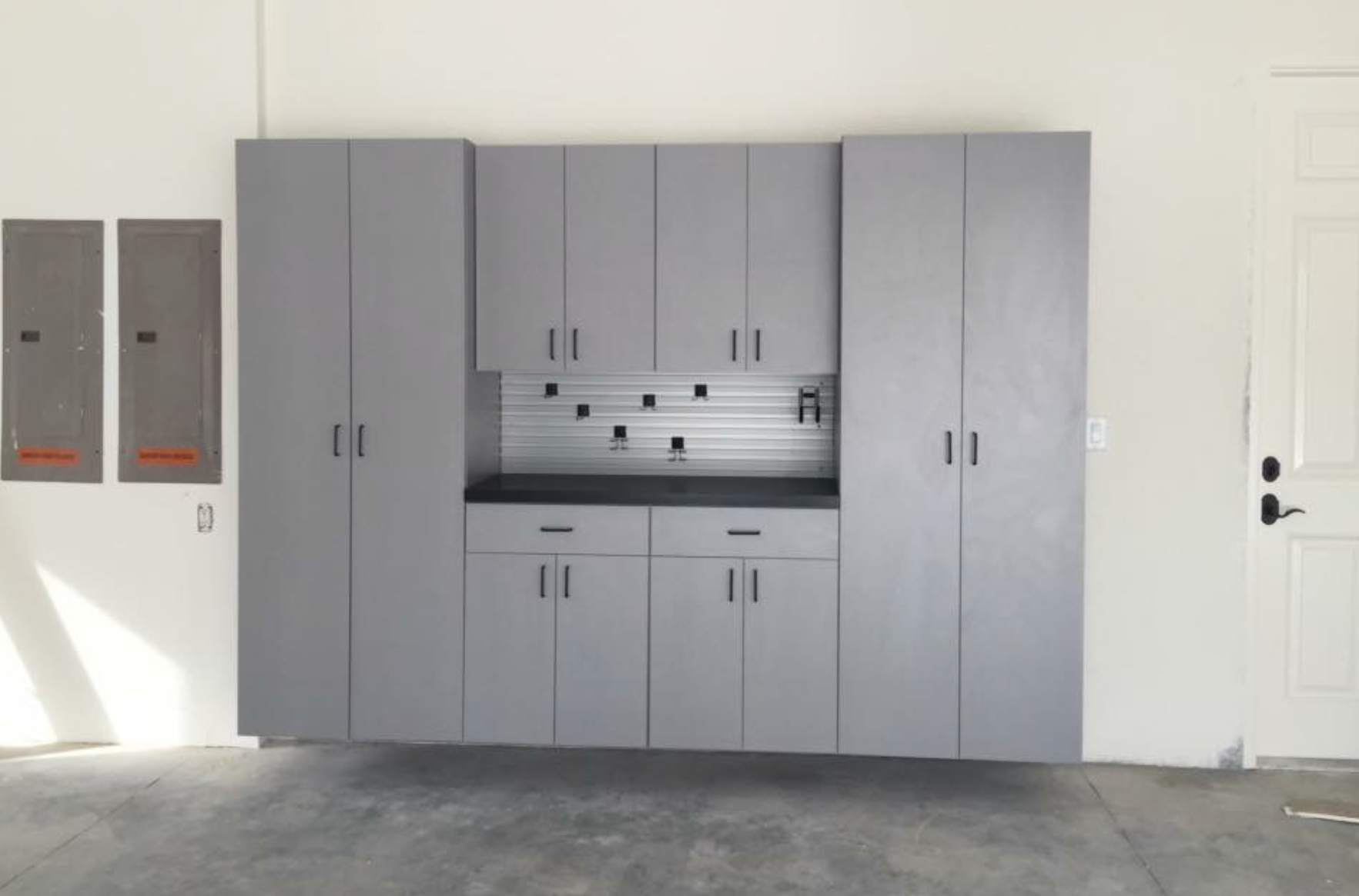 A garage with lots of gray cabinets and drawers