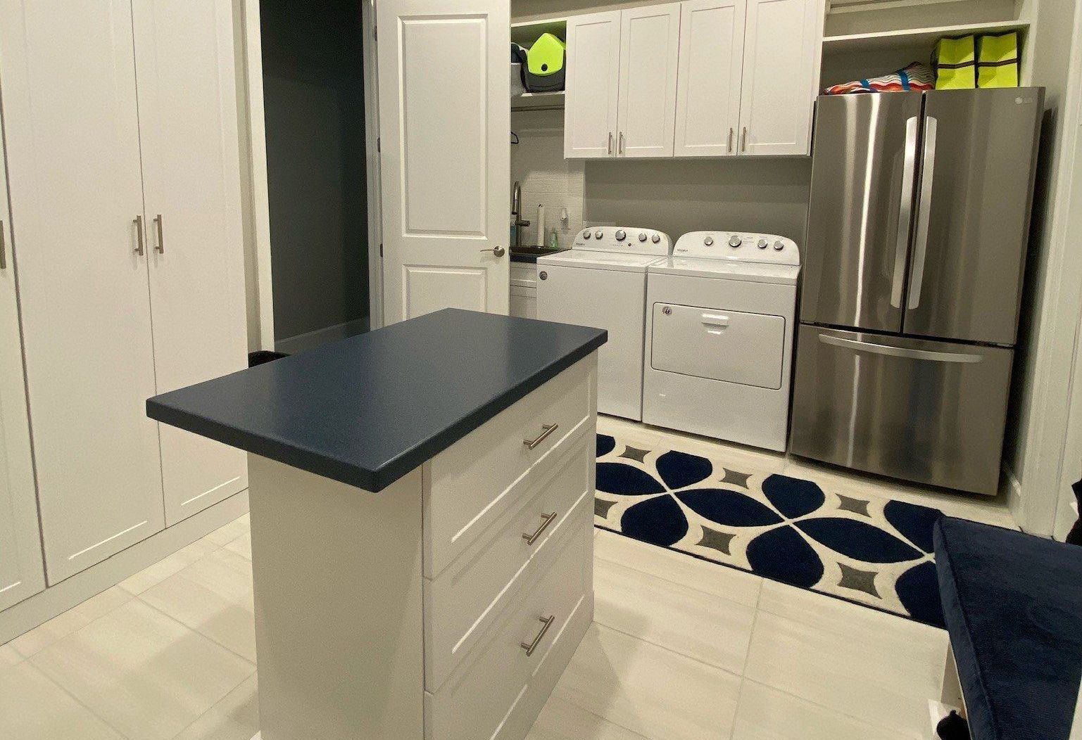 A laundry room with a large island in the middle