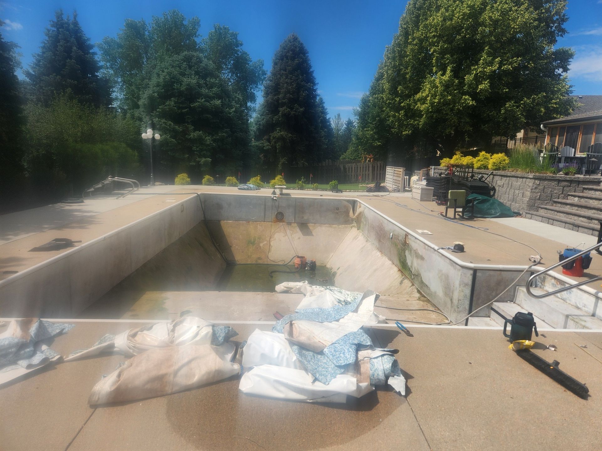 A swimming pool is being remodeled in a backyard.