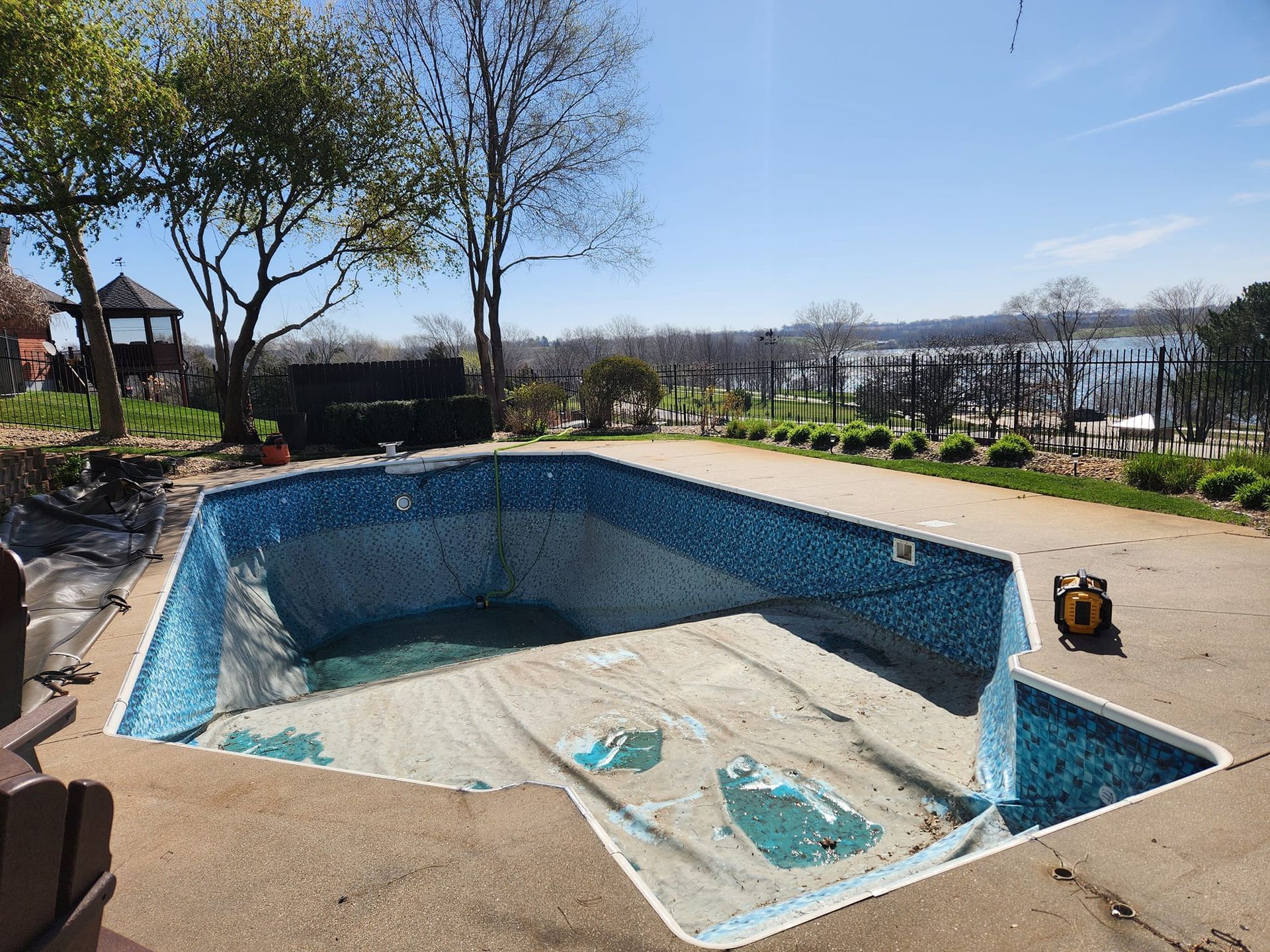 An empty swimming pool with a view of a lake