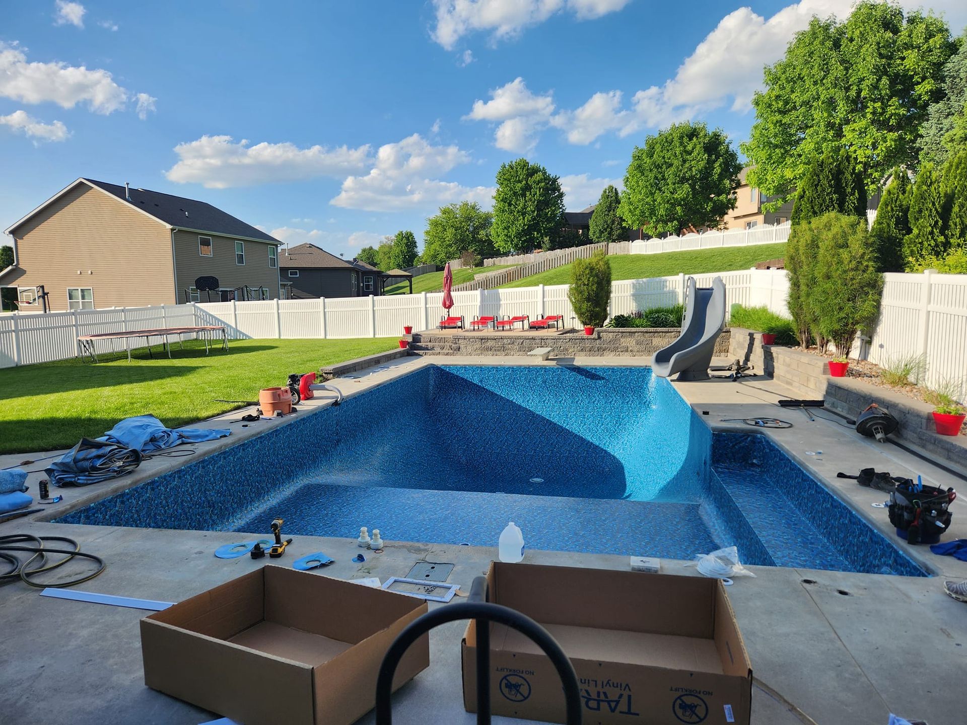 A large swimming pool is being built in a backyard.