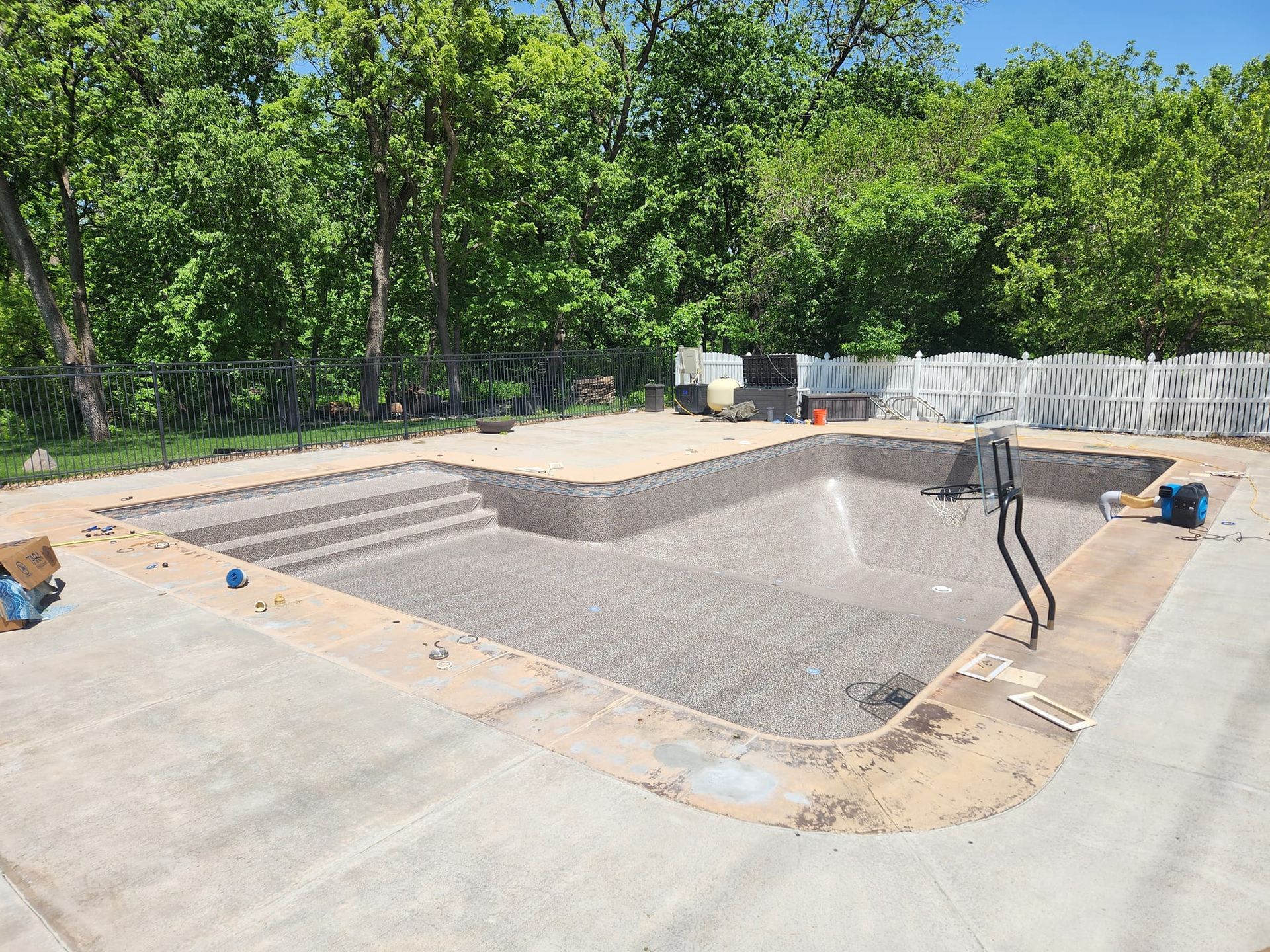 A large swimming pool is being built in a backyard.
