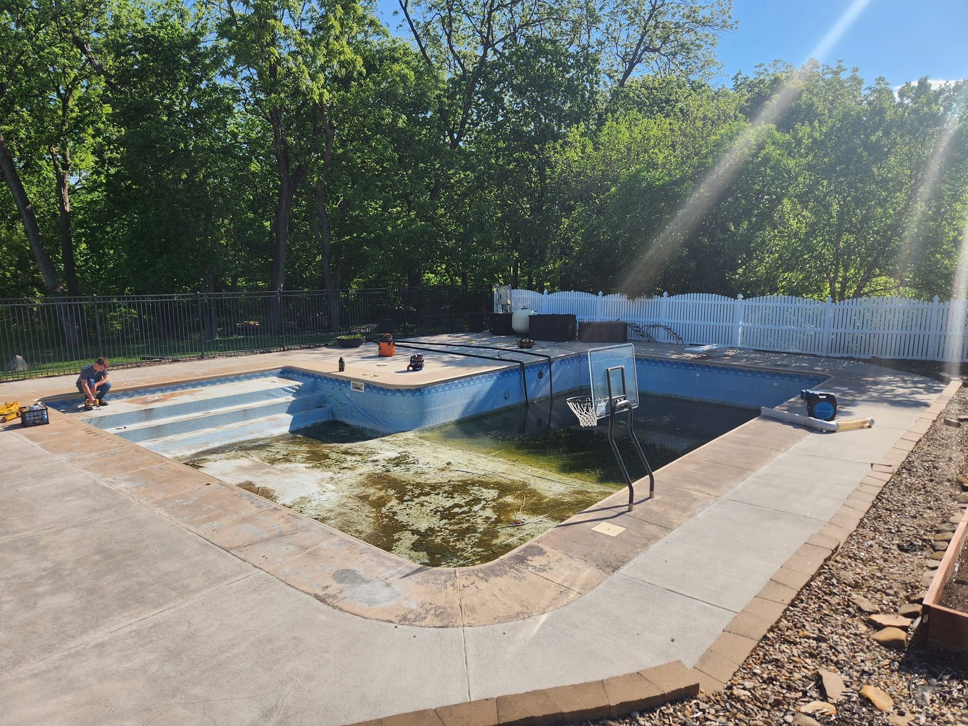 A swimming pool is being remodeled in a backyard.