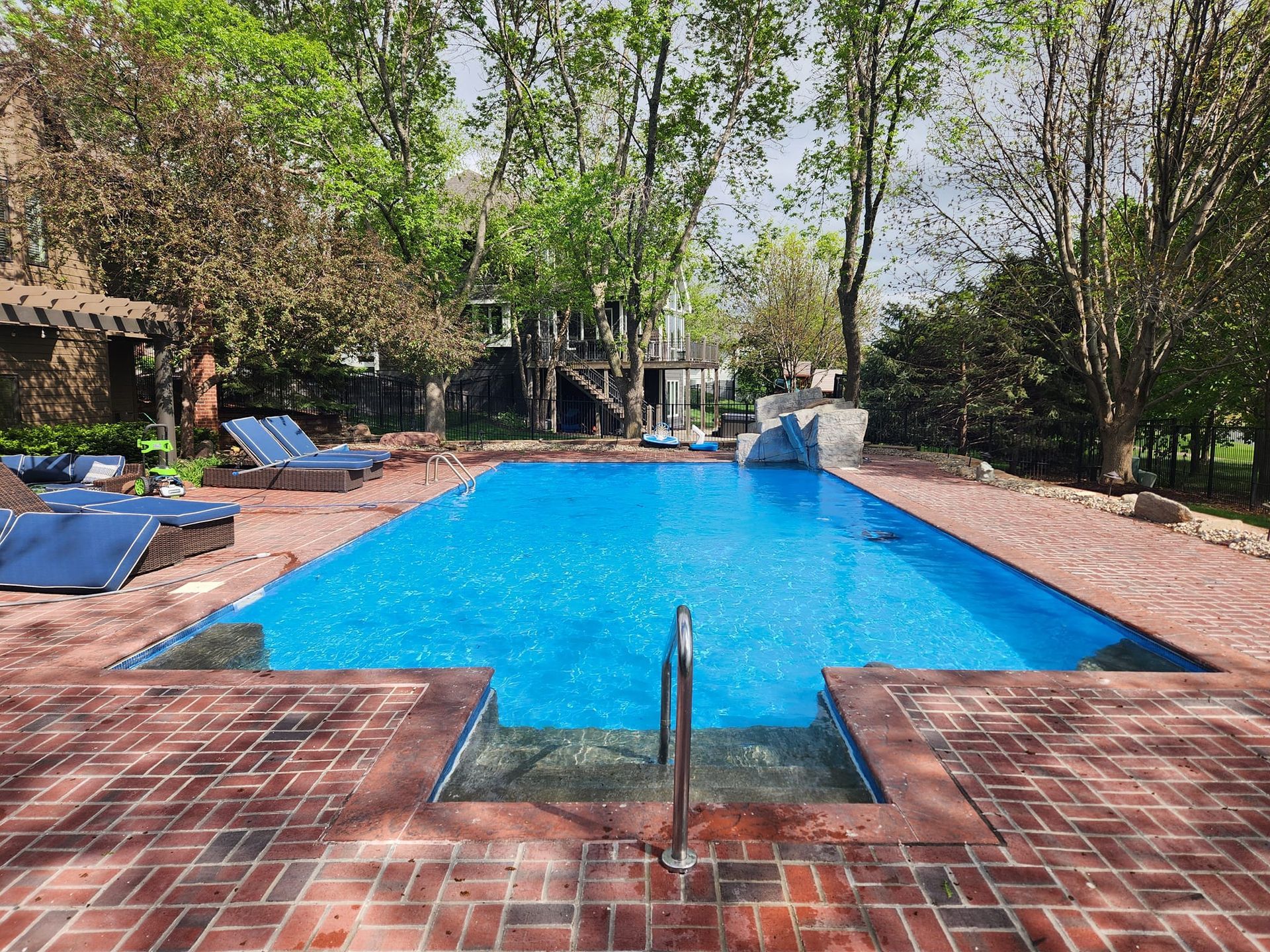 A large swimming pool surrounded by chairs and trees