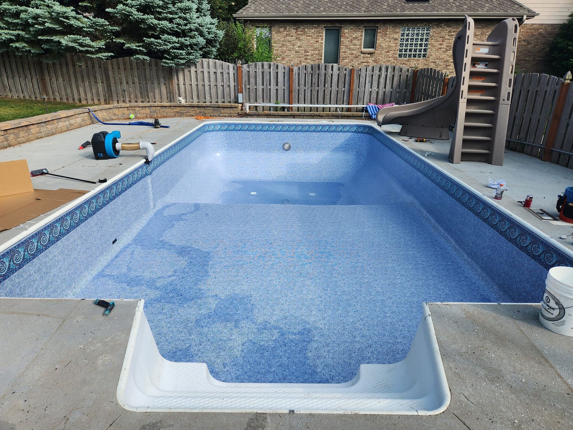 A large swimming pool is being built in a backyard