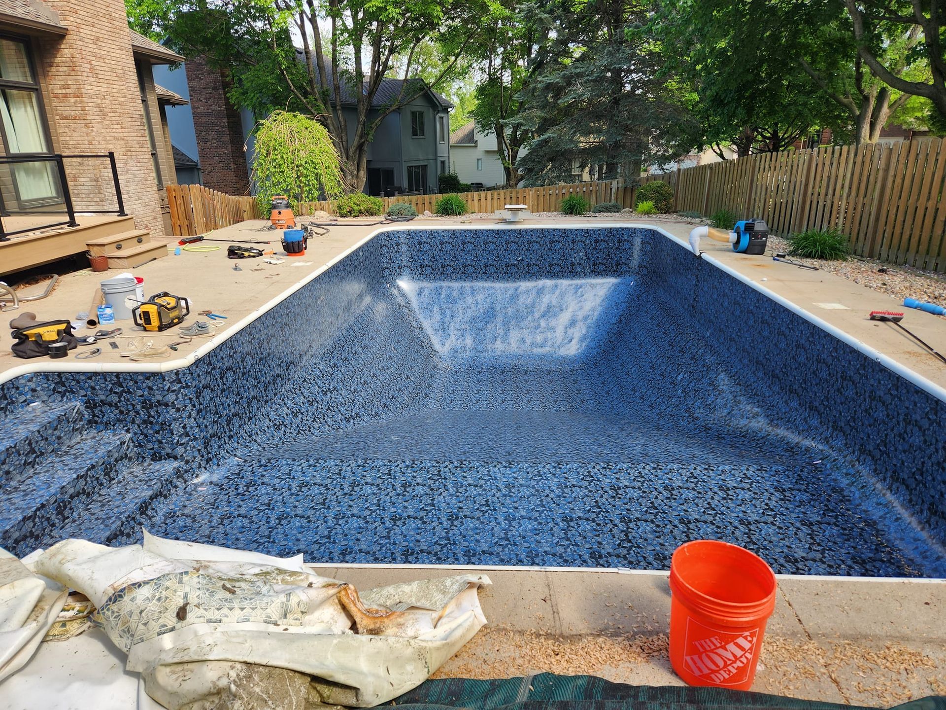 A large swimming pool is being built in a backyard.