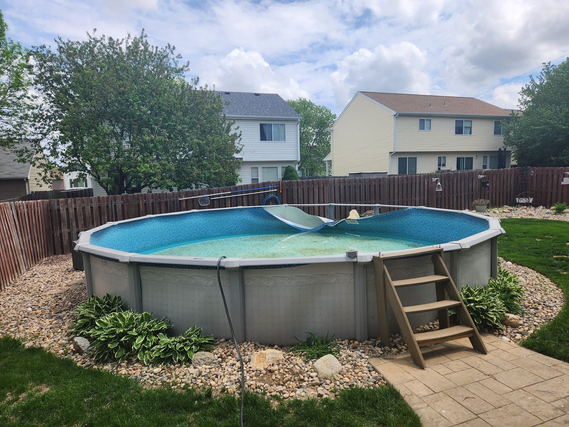 A large swimming pool is sitting in the backyard of a house.
