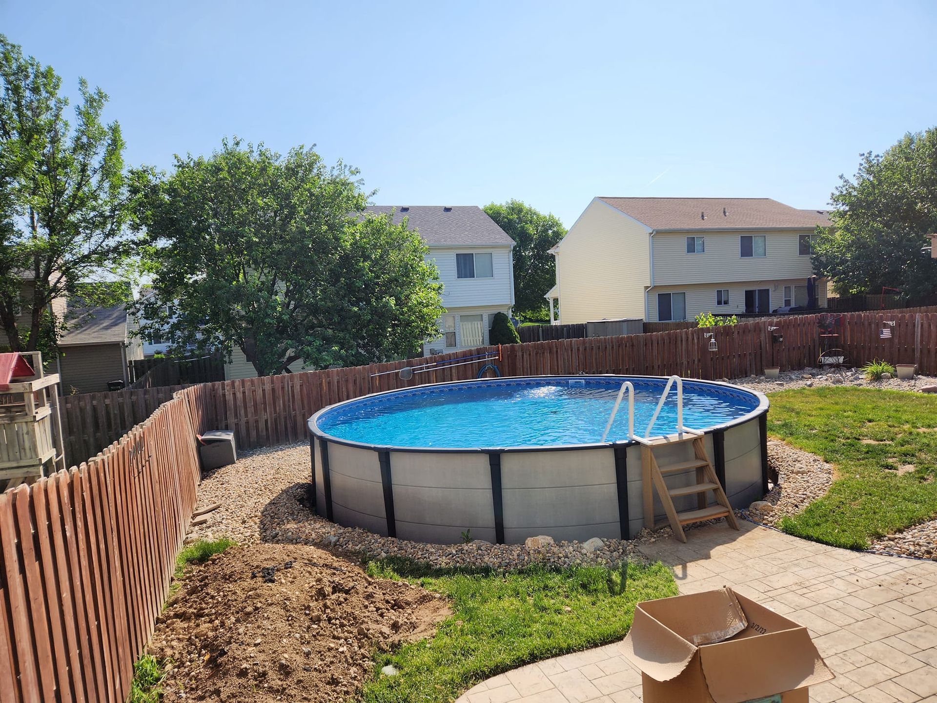 A large swimming pool is in the backyard of a house.