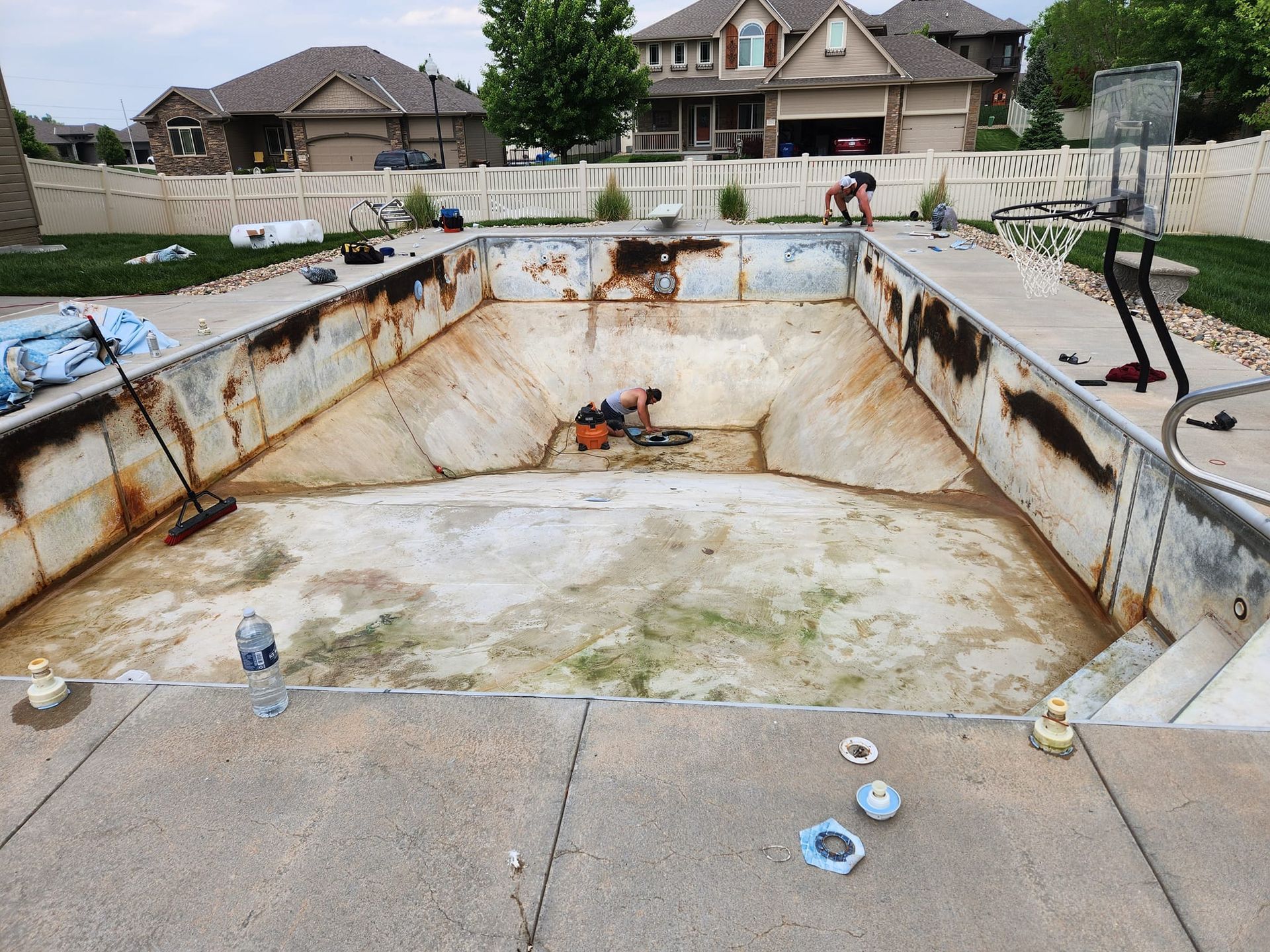 A swimming pool is being remodeled in a backyard.