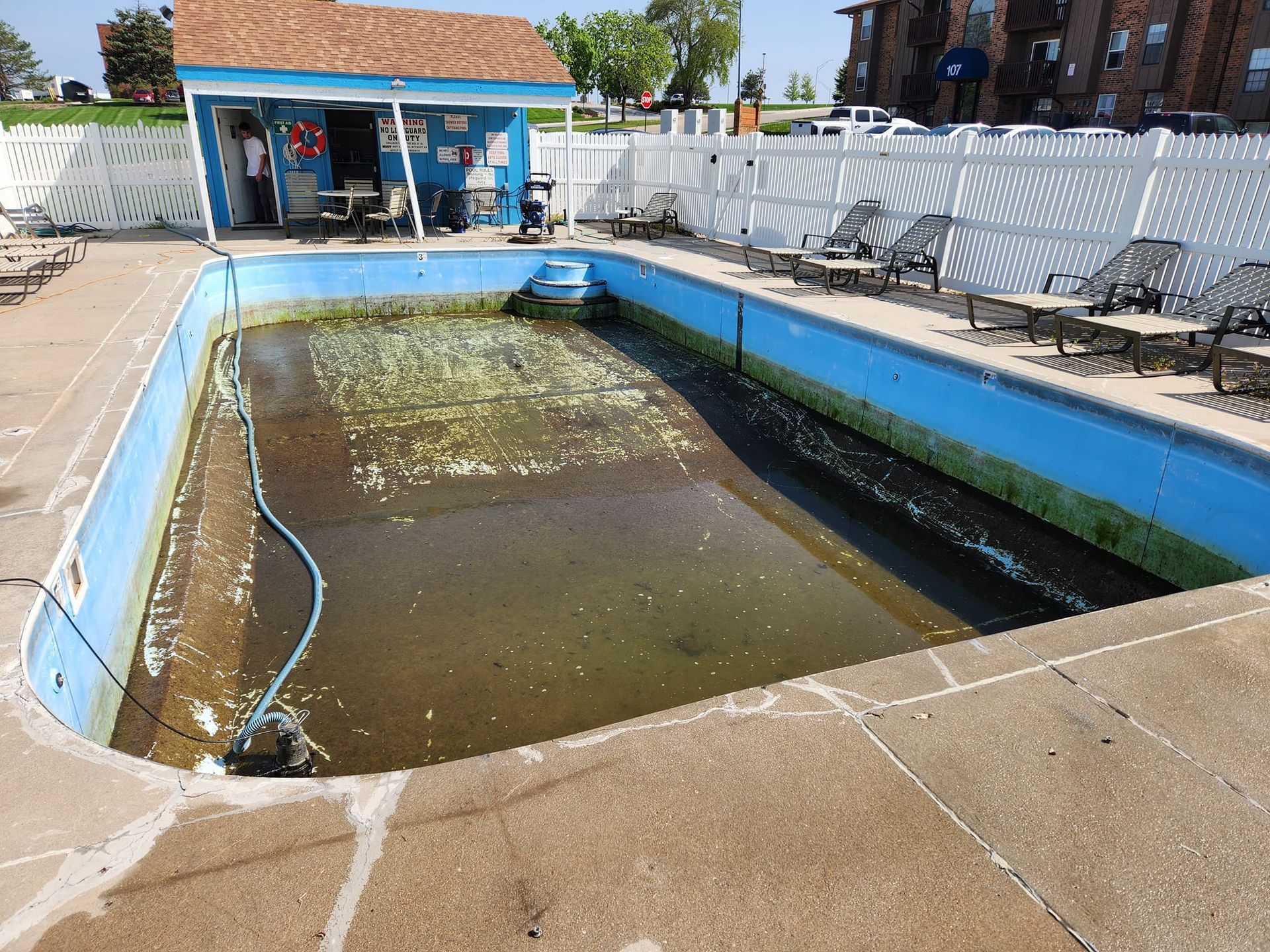 An empty swimming pool with a hose coming out of it