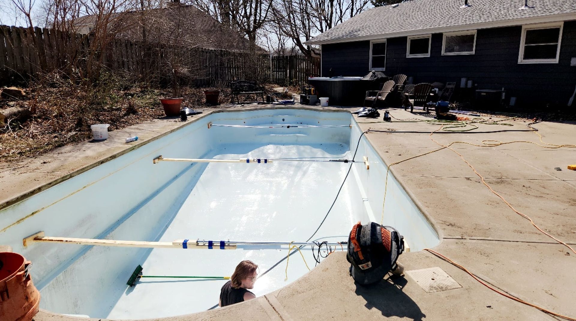 A swimming pool is being built in the backyard of a house