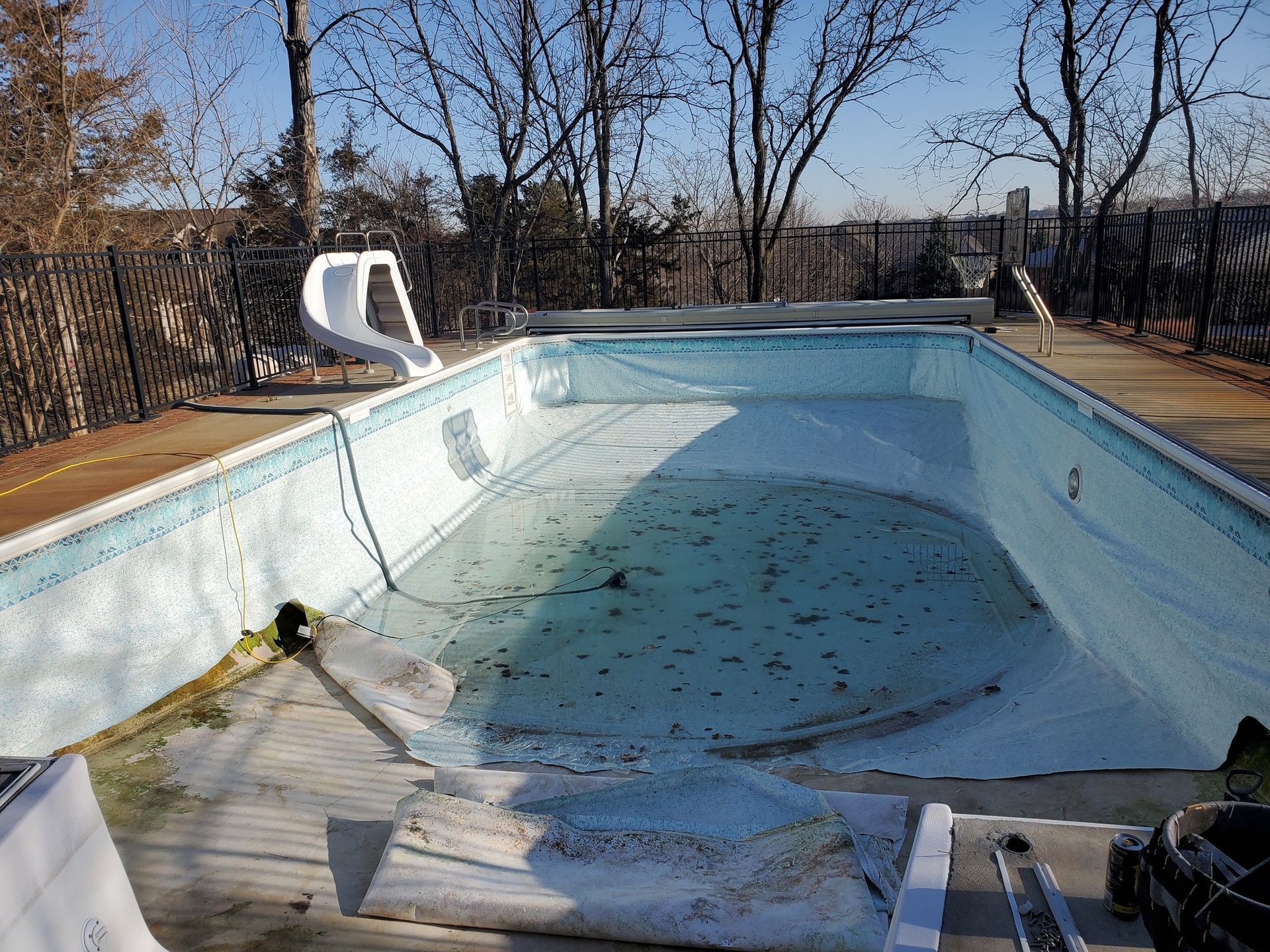 An empty swimming pool with trees in the background