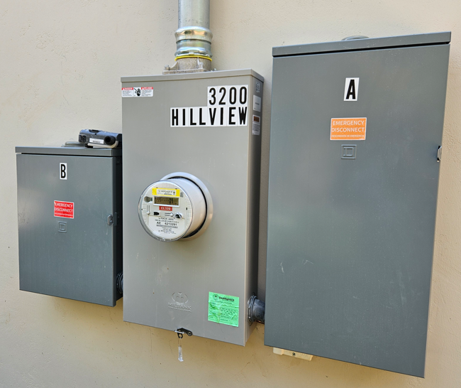 Three gray electrical panels mounted on a wall, labeled A, B, and 3200 Hillview.