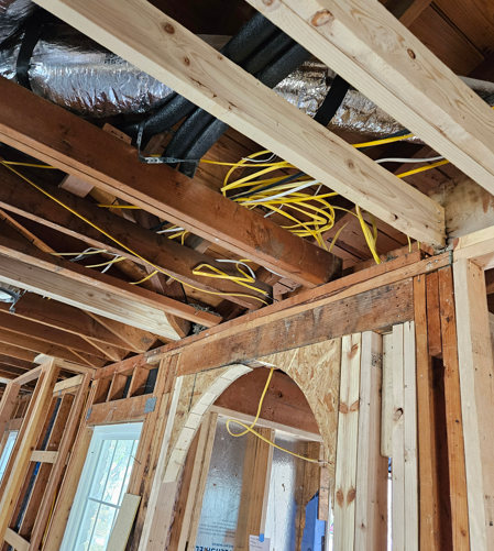 Framing and exposed wiring in an unfinished room under construction